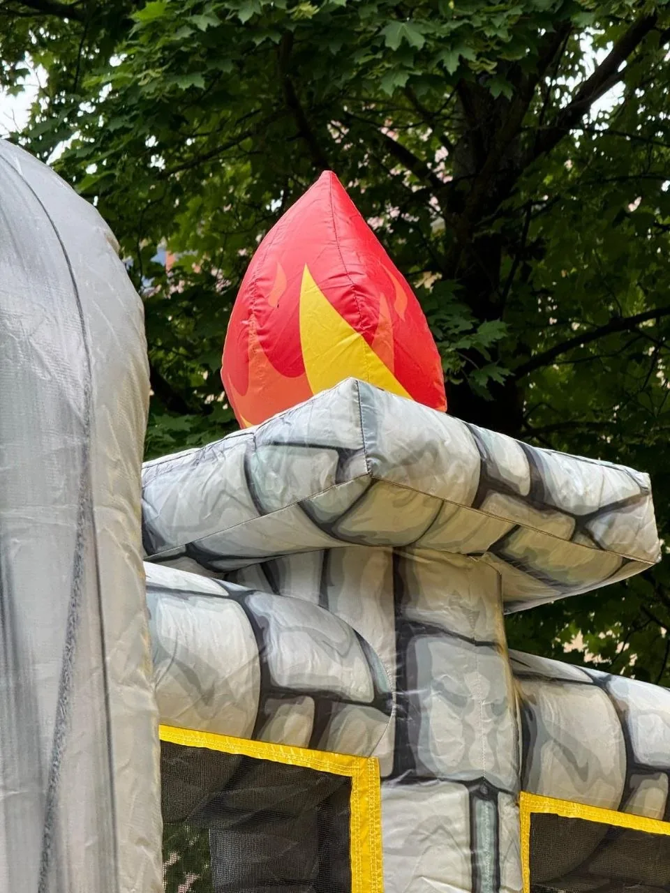 T-Rex-Hüpfburg — Flammen-Deko am Steinturm